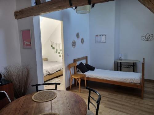 a room with a bed and a table and chairs at Zen suite Moulin de Vilaine in Châteauroux