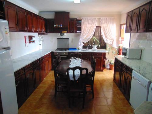 a kitchen with wooden cabinets and a table with chairs at Casa da Sogra in Faja Grande