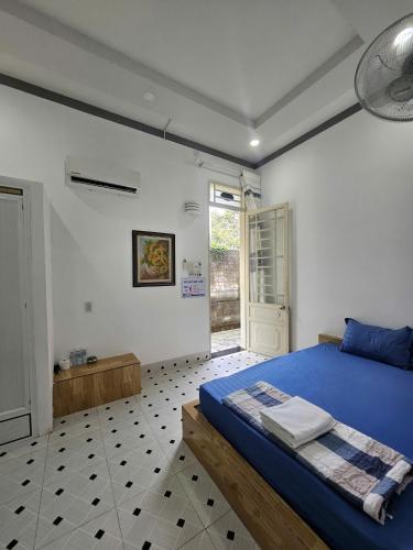 a bedroom with a blue bed and a window at Quốc Hưng in Ấp Trà Cô