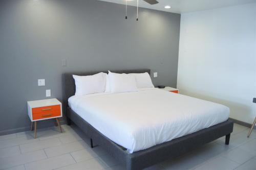 a bedroom with a large bed with white sheets at Musicland Hotel in Palm Springs