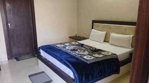 a bedroom with a bed with a blue blanket on it at Hotel Surya in Datia