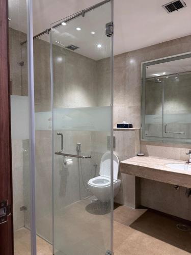 a bathroom with a toilet and a glass shower at Windsor House in Secunderabad