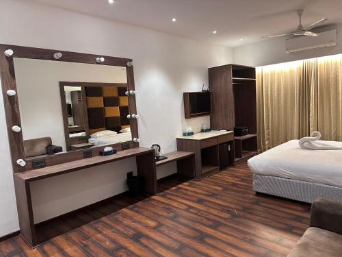 a hotel room with a bed and a mirror at Windsor House in Secunderabad