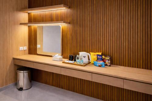 a bathroom with a counter with a mirror on it at Front One Hotel Mesir Surabaya in Surabaya