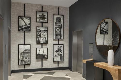 a room with pictures on a wall with a mirror at Hilton Baltimore BWI Airport in Linthicum Heights
