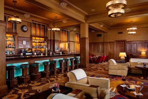 a lobby with a bar with chairs and tables at Arctic Club Hotel in Seattle