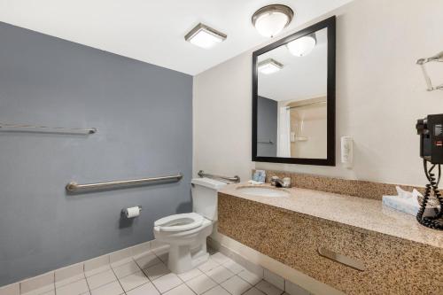 a bathroom with a toilet and a sink and a mirror at Sleep Inn Billings in Billings