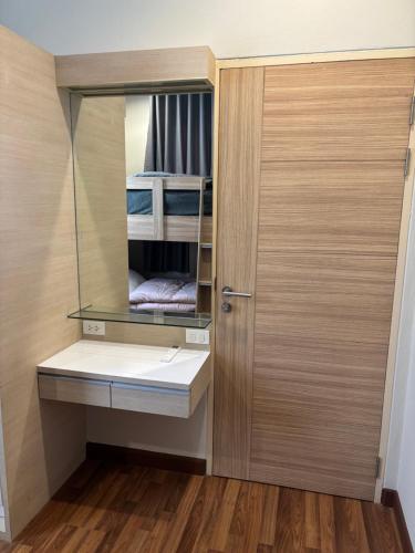 a bathroom with a mirror and a sink and a door at Vanilla Villa in Ban Yep Chaeng