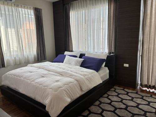 a bedroom with a large bed with blue pillows at Vanilla Villa in Ban Yep Chaeng