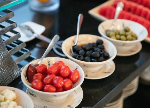 a group of bowls of tomatoes and olives on a table at MK Premier Boutique Hotel in Hanoi