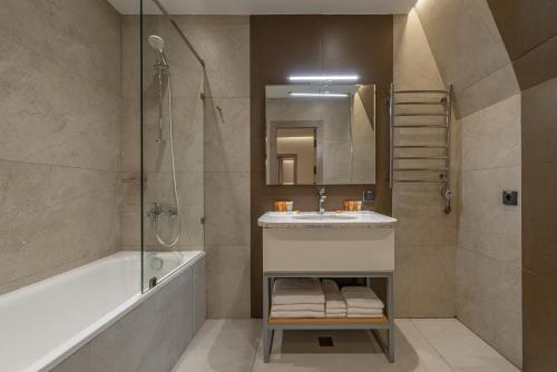 a bathroom with a tub and a sink and a shower at Apart Hotel Istaravshan in Tashkent
