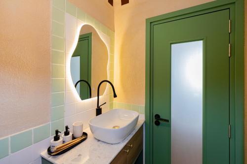 a bathroom with a sink and a green door at Hội Home in Ho Chi Minh City