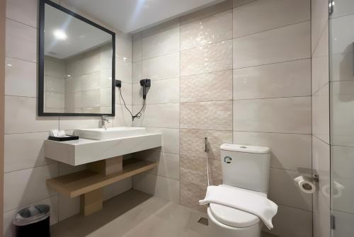 a bathroom with a toilet and a sink and a mirror at MAXONE Batam in Nagoya