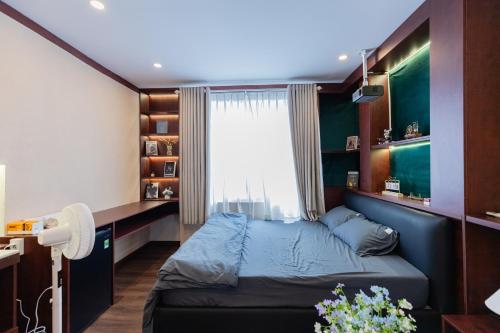 a bedroom with a blue bed and a window at Hội Home in Ho Chi Minh City
