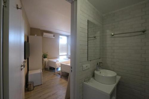 a white bathroom with a sink and a mirror at Boutique Hotel Meidan View in Tbilisi City