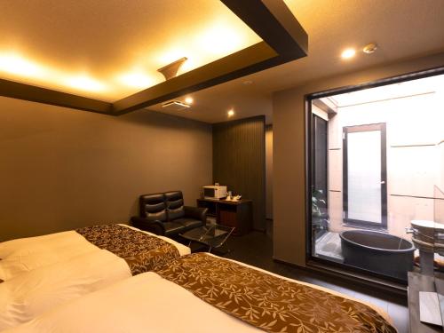 ein Schlafzimmer mit Bett und ein Badezimmer mit Badewanne in der Unterkunft 大分温泉 Business Resort Sourin in Ōita