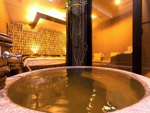 ein Badezimmer mit Badewanne und Waschbecken in der Unterkunft 大分温泉 Business Resort Sourin in Ōita