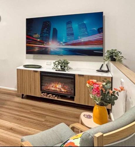 a living room with a tv and a fireplace at Luxe suite in Darling Harbour with pool, sauna & gym - ICC 300m in Sydney