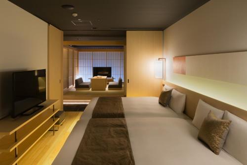 a hotel room with a couch and a television at hotel kanra kyoto in Kyoto