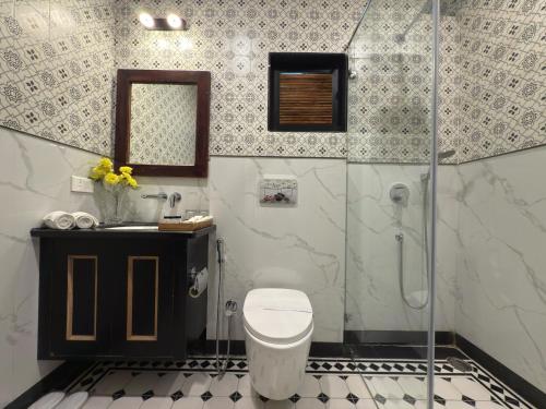 a bathroom with a shower and a toilet and a sink at Kaner Bagh A Heritage Boutique Hotel in Udaipur