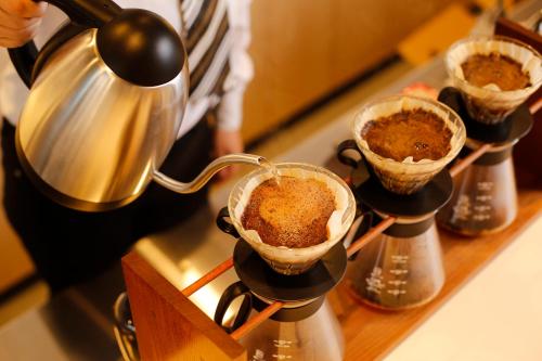 a person is preparing food in cups on a counter at hotel kanra kyoto in Kyoto