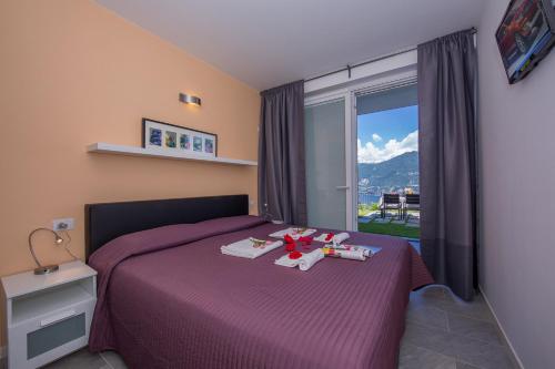 sypialnia z fioletowym łóżkiem i oknem w obiekcie Casa Laura Apt 3 w mieście Menaggio