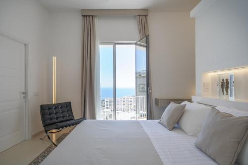 a bedroom with a large white bed and a window at Sopramonte Exclusive Rooms in Capri