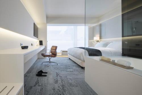 a bedroom with two beds and a desk and a chair at Swiio Hotel Daan in Taipei