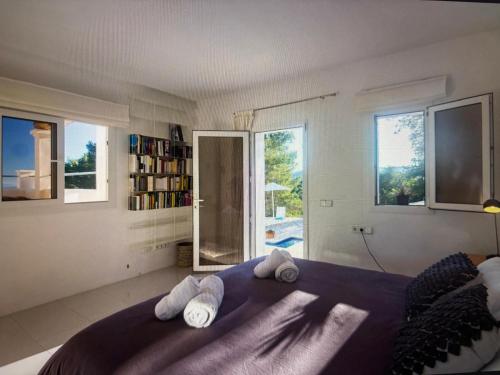 a bedroom with a purple bed with towels on it at Villa Casiopea in Illes Balears