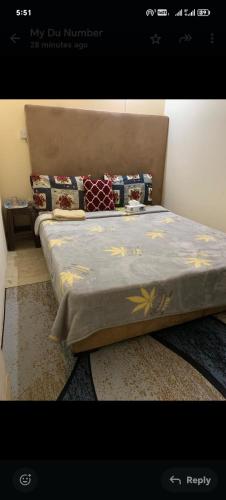 una camera da letto con un letto con un piumone blu di Adex Cool Apartment a Abu Dhabi