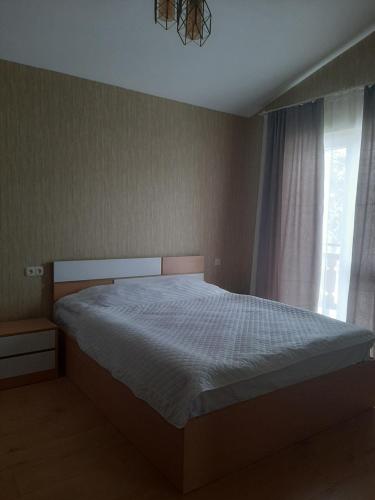 a bedroom with a bed and a window at Cozy Cottage Bakuriani in Bakuriani