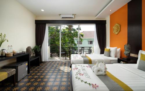a hotel room with two beds and a balcony at Indochine Sanctuary Boutique in Siem Reap