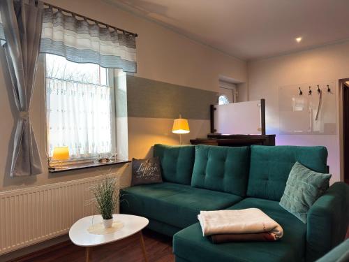 a living room with a green couch and a tv at Charmante Ferienwohnung mit Garten in Wiek in Wiek auf Rügen