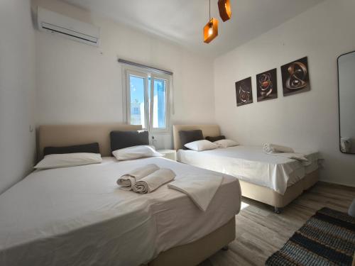 a bedroom with two beds with towels on them at VILLA VASILIS ORNOS in Mikonos