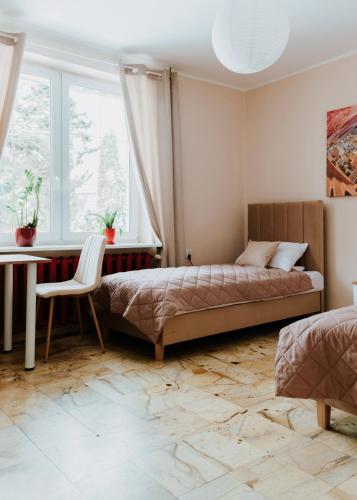 a bedroom with a bed and a desk and a window at Vistula City in Płock