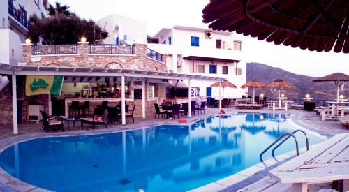 a large blue swimming pool next to a building at Hermes-Ios Rooms To Let in Ios Chora