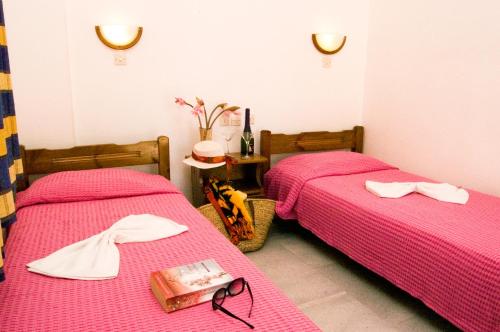 two beds in a room with pink sheets at Summer Time in Ios Chora