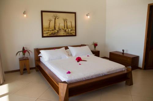 a bedroom with a bed with flowers on it at Hotel Mahita Tsara in Djamandjary