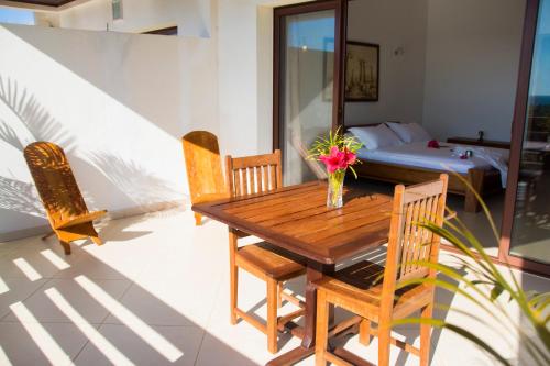 a wooden table and chairs in a room with a bed at Hotel Mahita Tsara in Djamandjary