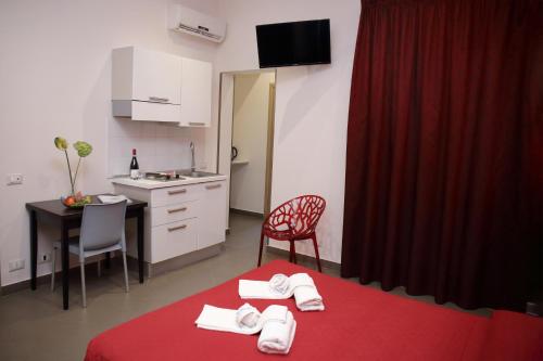 a room with a red bed with towels on it at Palazzo Dei Corsari in Trapani
