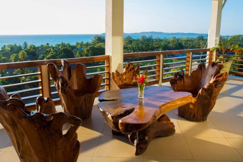 a wooden table and chairs on a balcony at Hotel Mahita Tsara in Djamandjary