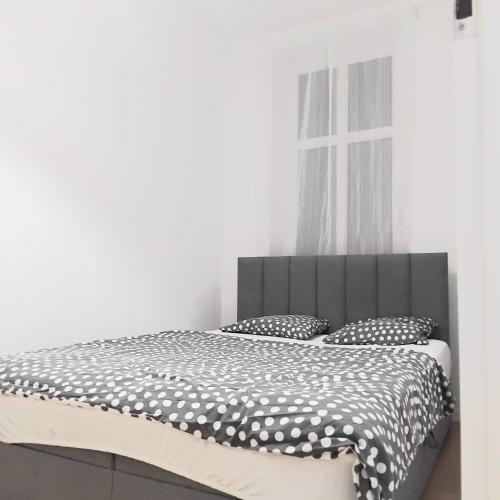 a bedroom with a bed with a black and white comforter at Klonowicza UP in Leszno