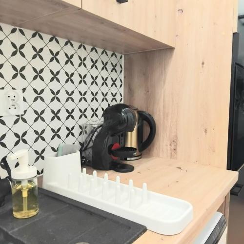 a kitchen counter with a black and white tile wall at Klonowicza UP in Leszno
