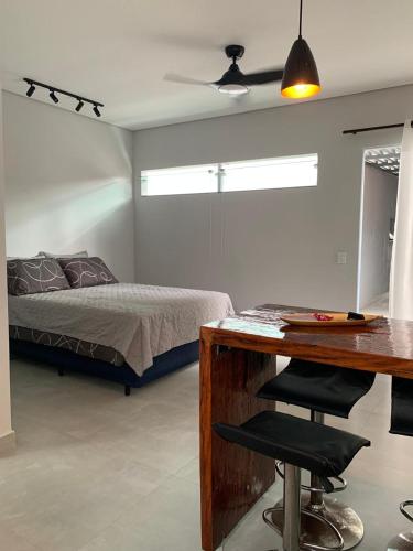 a bedroom with a bed and a desk with a desk at Lua nova Studio I in Caraguatatuba