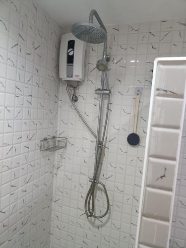 a shower in a white tiled bathroom at VIP condochain 24th floor in Ban Phe