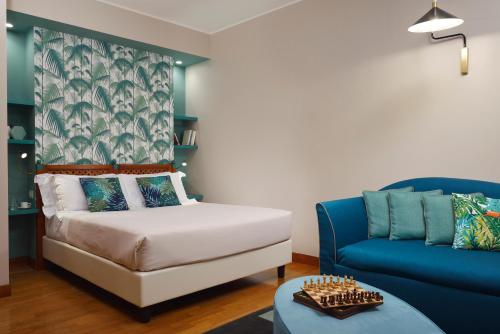 sypialnia z łóżkiem i niebieską kanapą w obiekcie Residenza delle Città w Mediolanie