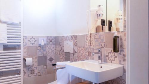 a bathroom with a sink and a mirror at Hotel Spinnerhof in Sasbachwalden