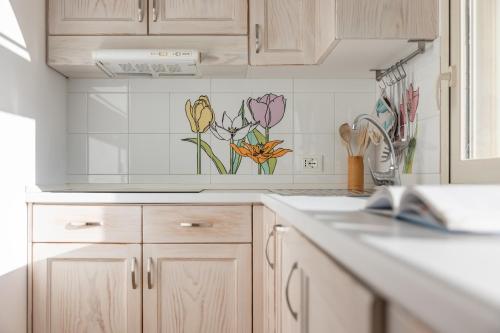 a kitchen with flowers painted on the wall at Agriturismo Residenza Gemma in Porto Cesareo