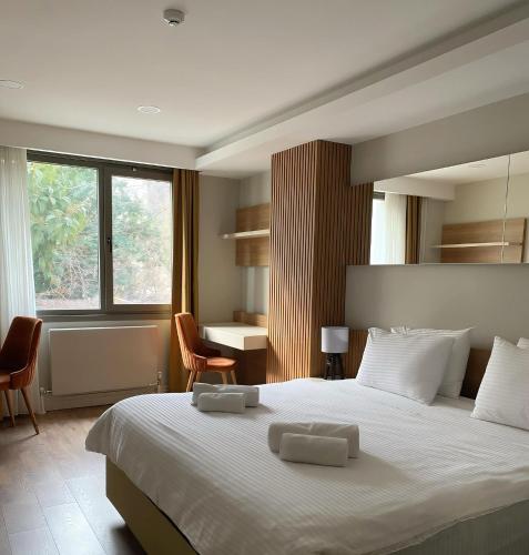 a bedroom with a large white bed with two chairs at Frezya Family Hotel in Istanbul