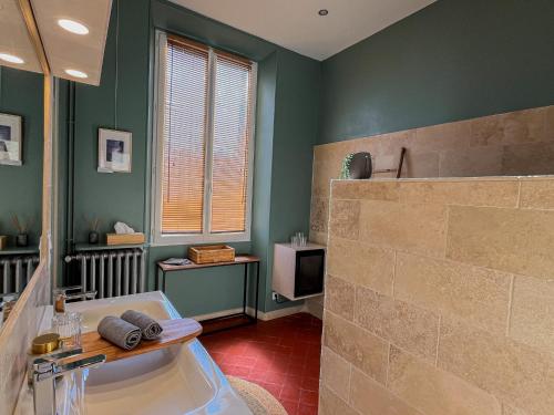 a bathroom with a tub and a television in it at La maison Gerval in Bédoin
